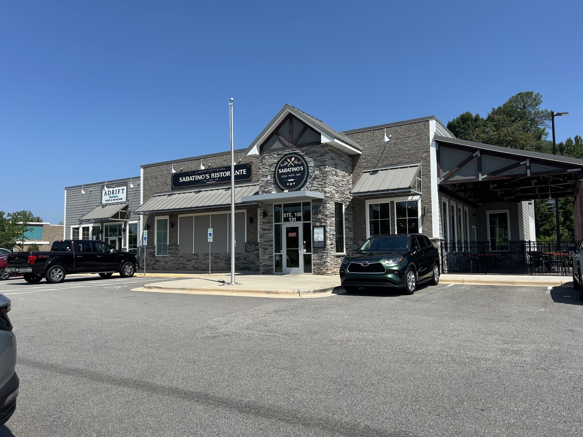 Sabatino's Ristorante and Adrift Hair & Skincare storefronts in a modern stone-faced commercial building