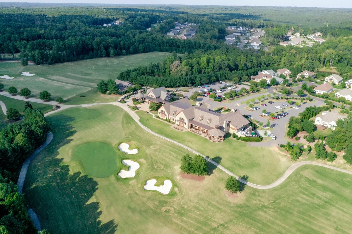 Aerial view of the Hasentree golf course and clubhouse surrounded by woods