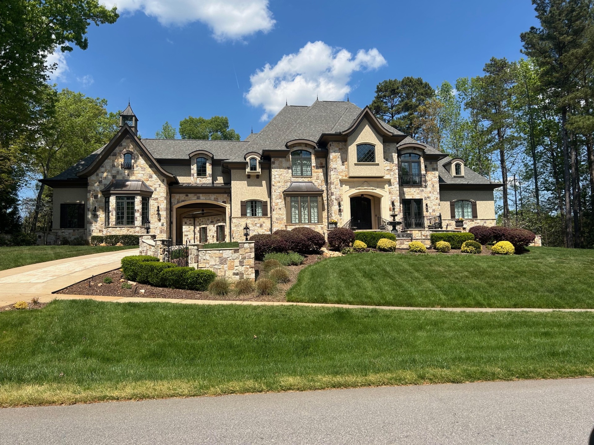 Luxury estate home with stone facade and manicured lawn in Hasentree